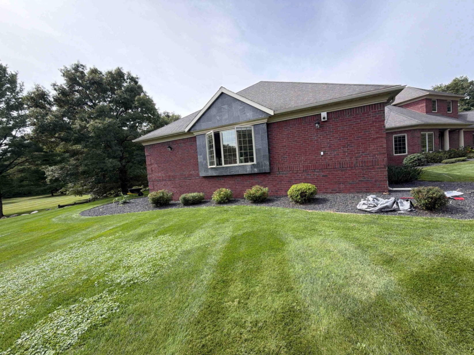 Decorative rock beds and trimmed shrubs along a Central Wisconsin home after landscaping by No Plan LLC